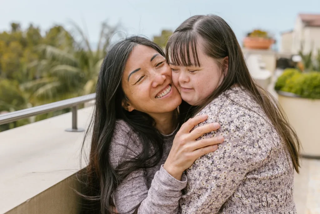 Support worker hugging disabled girl