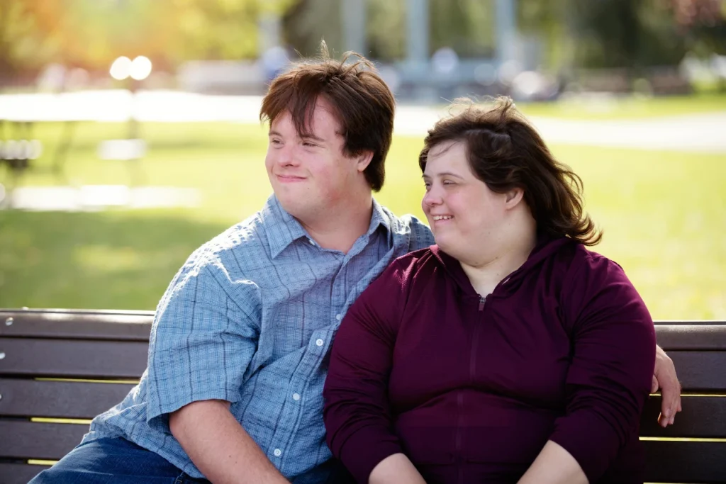 Two disabled friends sitting on park bench