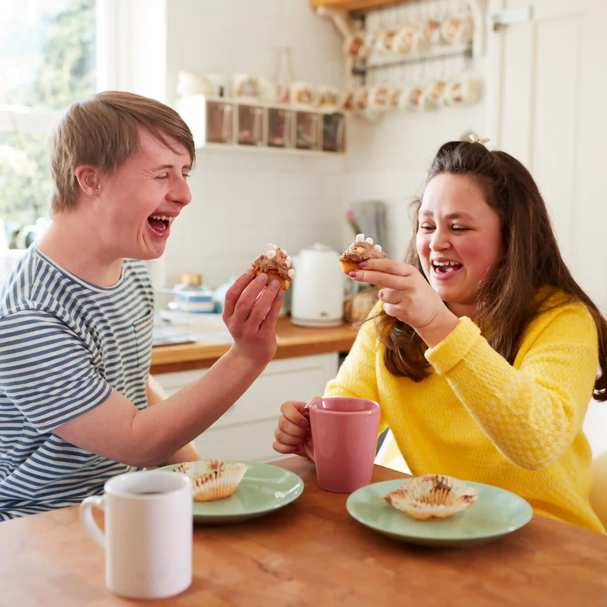 Two disabled friends eating cupcakes