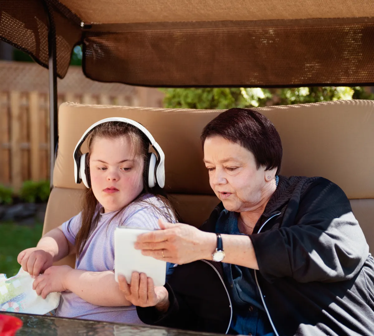 Disabled woman looking at tablet with support worker
